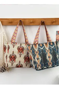 Vista detallada de dos bolsos de mano tejidos bohemios con patrones geométricos étnicos