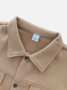 Close-up detail of a men's tan lapel jacket showing fabric texture and size tag