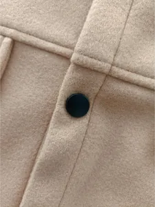 Detailed close-up showing the camel wool jacket fabric texture and a black circular button