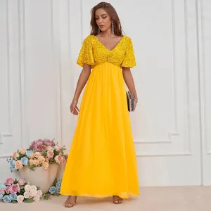 Robe de soirée jaune élégante à col en V avec bustier pailleté et jupe longue en mousseline.