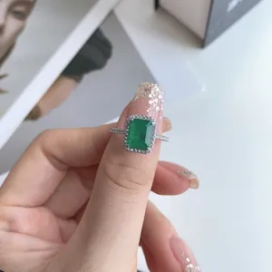 Close-up of S925 silver ring featuring emerald-cut green cubic zirconia halo design