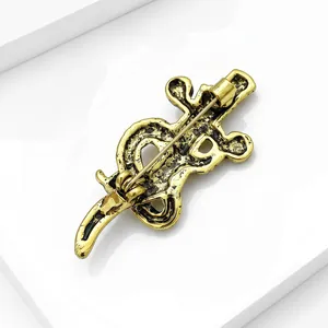 Detail view of a vintage gold alloy snake and sword brooch showing the secure back pin.