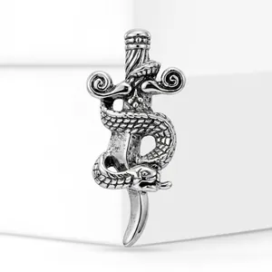 Detail view of a vintage silver-colored alloy brooch featuring a snake coiled around a dagger.