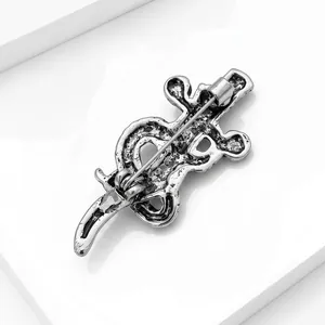 Detailed close-up of a vintage silver alloy snake and sword brooch with textured finish