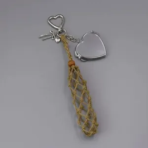 Detailed view of hand-woven lipstick pouch featuring silver heart locket and bow charms