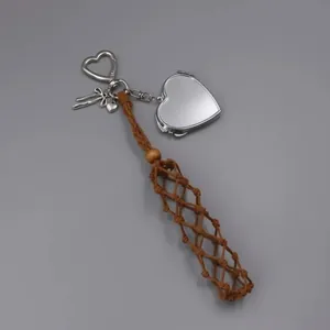 Handwoven brown lipstick net keychain featuring a silver heart mirror and ribbon charm