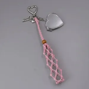Close-up view of pink handmade woven mesh lipstick holder featuring a silver heart mirror