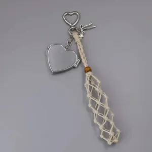 Macro view of handmade cream woven mesh pocket and silver heart locket bag pendant charm