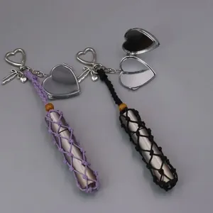 Detailed view of hand-woven lipstick holder keychain with a heart-shaped mirror charm