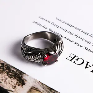 Vintage silver wing ring featuring a brilliant round red gemstone in a gothic style.