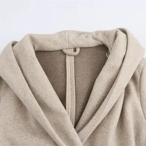 Close-up detail of the soft oatmeal beige wool blend hooded coat showing inner lining and loop.