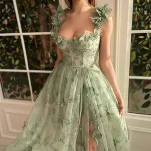 Détail d'une robe de fée vert sauge avec de magnifiques appliques papillons en 3D.