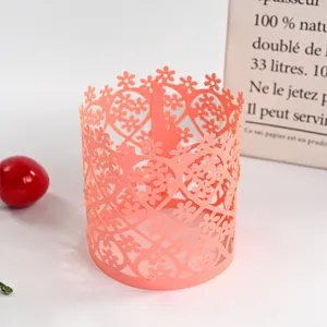 Detailed macro view of laser-cut floral and heart pattern on coral paper candle sleeve