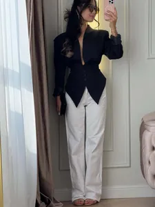 Professional detailed shot of a black slim-fit blazer with cinched waist and V-neck