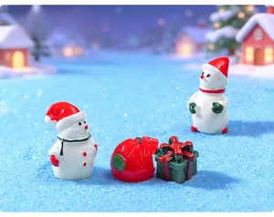 Detailed view of miniature Christmas resin figurines with cute snowmen and gift boxes