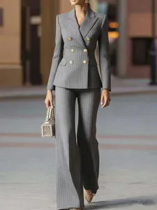 Full-body street style view of an elegant grey pinstripe suit set with decorative gold buttons