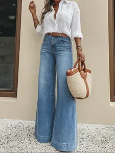 Detailed view of women's retro light blue washed high-waisted wide-leg denim jeans