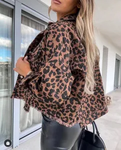 Side detail of a cropped leopard print denim jacket featuring a distressed raw hem