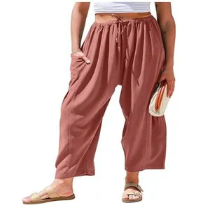 Detail showing the comfortable elastic drawstring waist and relaxed fit of rust pink linen trousers