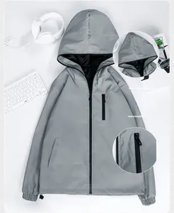 Detail view of a grey reflective hooded windbreaker with zippered pockets for men