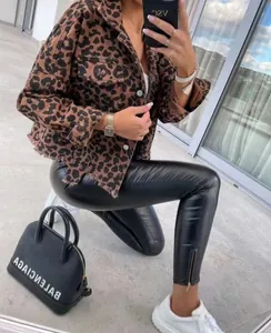 Stylish cropped leopard print denim jacket styled with black leather pants on a terrace