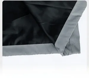 Macro view of the hem detail with grey reflective strip on a black outdoor windbreaker