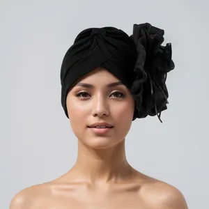 Detail view showing the elegant design of black turban with a large side flower decoration