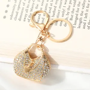 Close-up of golden alloy handbag keychain with heart charm and sparkling rhinestones