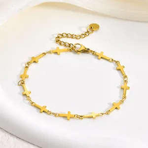 Detail view of a gold stainless steel bracelet featuring multiple cross-shaped links.