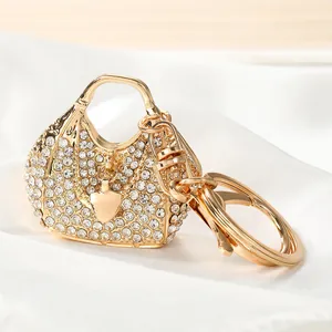 Close-up of sparkling rhinestone-studded handbag keychain with gold heart charm.