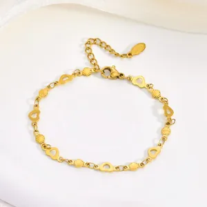 Close-up detail of a gold stainless steel bracelet featuring delicate hollow heart shaped links.