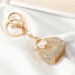 Close-up detail of a elegant gold handbag keychain encrusted with sparkling white rhinestones