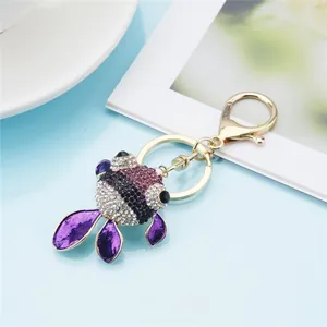 Detailed macro view of a cute goldfish keychain with purple rhinestones and gold hardware