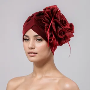 Elegant burgundy velvet turban hat with large floral detail worn by a female model.