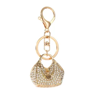 Macro detail of a shimmering rhinestone-studded handbag keychain with a gold heart charm