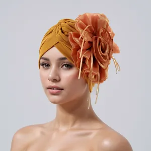 Detail view of an elegant yellow turban hat with a large mesh flower and streamers