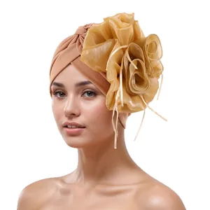 Elegant women's turban hat featuring a large organza side flower and breathable fabric.
