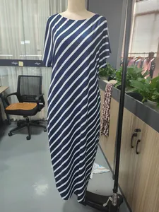 Detail view of navy blue and white diagonal striped maxi dress on mannequin in workspace