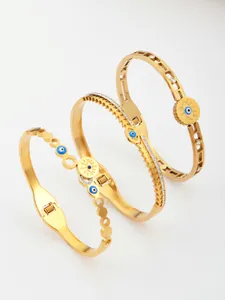 Dettaglio ravvicinato di tre bracciali placcati oro con malocchio e zirconi scintillanti