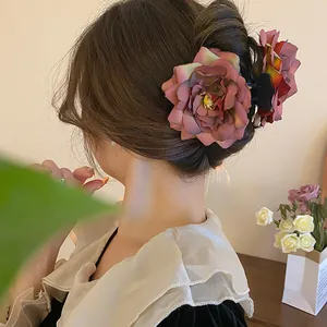 Grande pince à cheveux en tissu rose séchée élégante montrant une coiffure en chignon