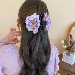 Vue détaillée d'une pince à cheveux rose en tissu violet pour un coiffage élégant