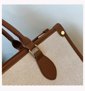 Detailed close-up of handle attachment and woven texture on a canvas tote bag