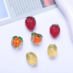 Detailed macro view of colorful fruit-shaped lampwork glass beads for DIY jewelry making