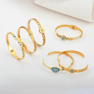 Set elegante goudvergulde titanium stalen armbanden met beschermende blauwe Evil Eye bedels.