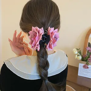 Gros plan détaillé montrant la pince à cheveux en tissu rose sur une coiffure tressée