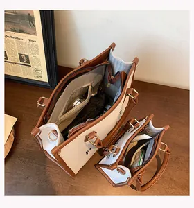 Interior detail of two canvas tote bags with brown leather trim and zipper pockets