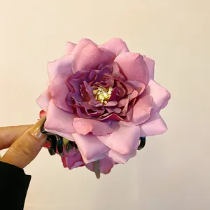 Gros plan d'une pince à cheveux rose en tissu élégante avec pétales multicouches