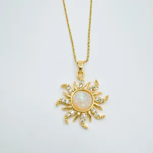 Gros plan d'un pendentif soleil doré de style vintage avec opale et pierres claires