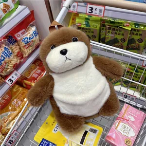 Gros plan d'un sac en peluche loutre de mer marron et blanc dans un chariot de course