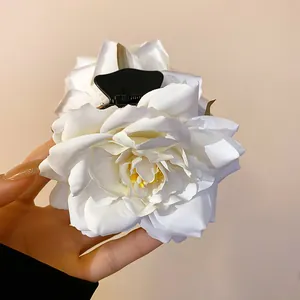 Gros plan détaillé d'une grande pince à cheveux élégante en rose de tissu blanc pur